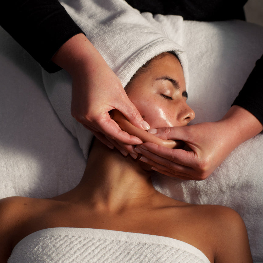Person receiving a facial massage in a spa setting