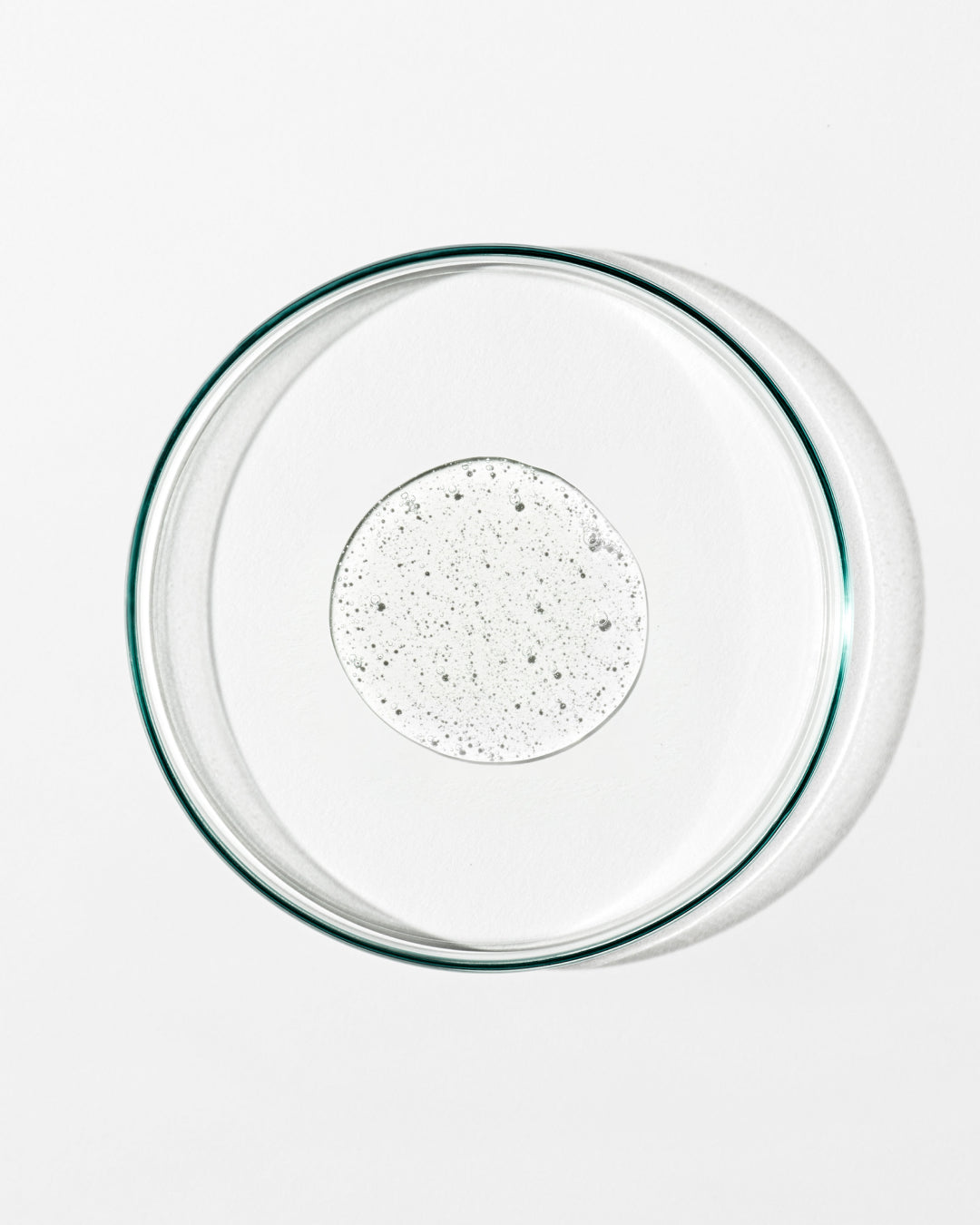Clear glass pie dish with speckled liquid on a white background