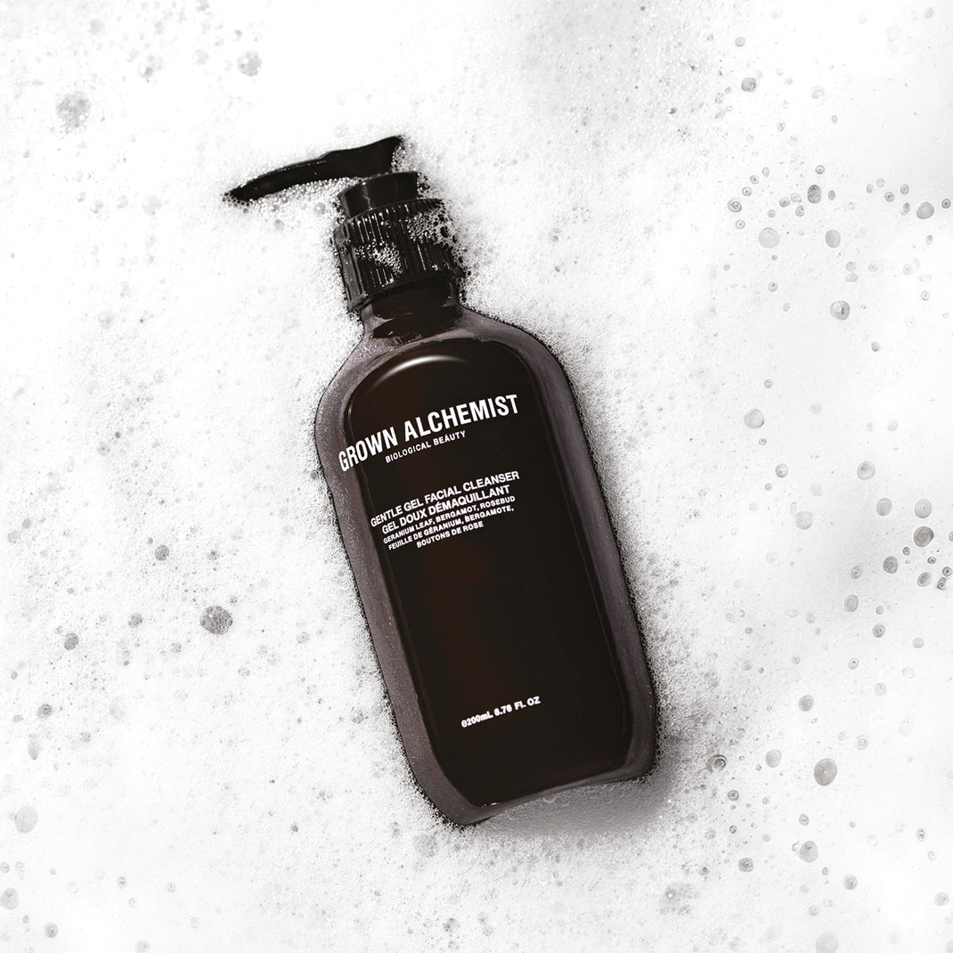 Pump bottle of Grown Alchemist Cleanser surrounded by foam