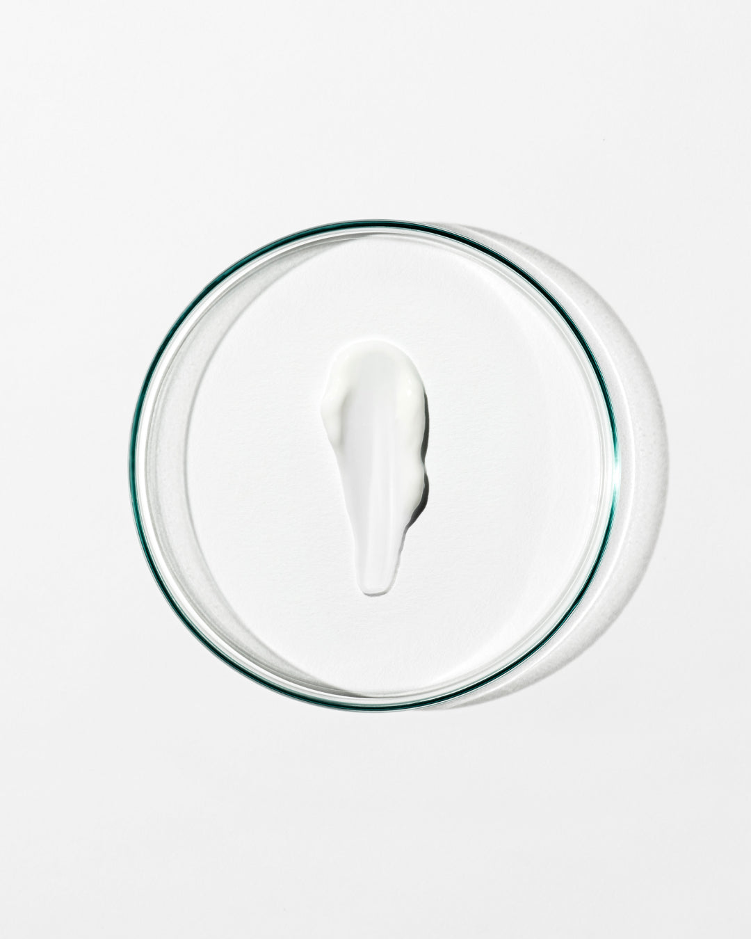 Glass lid with a circular dollop of cream on a white background