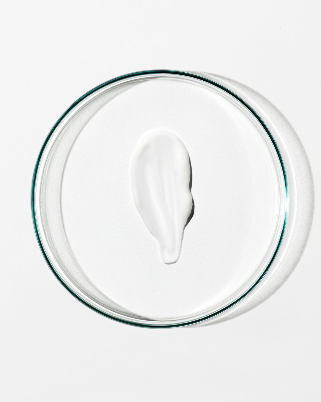 White cream on a clear glass plate with a white background