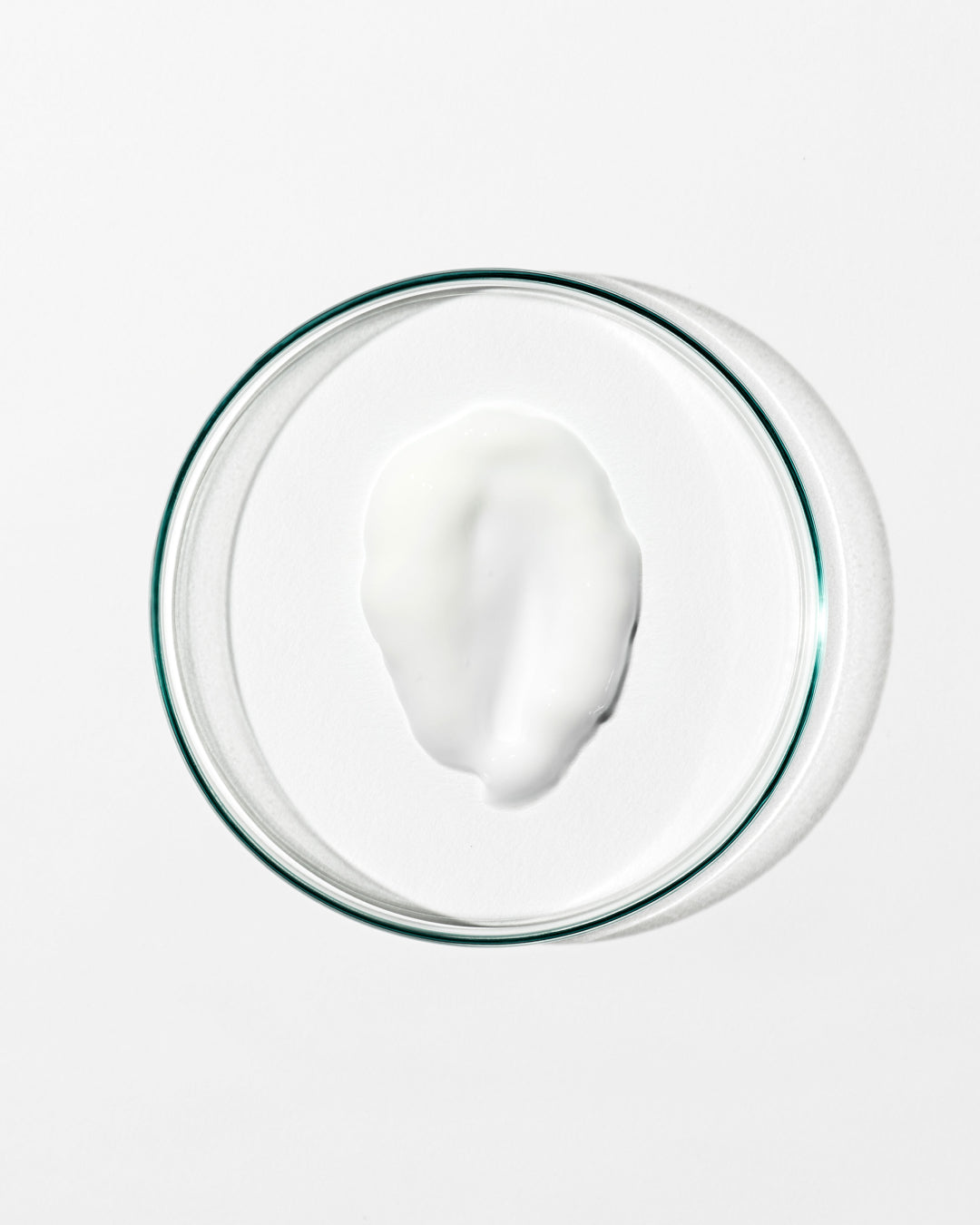Glass bowl with a white creamy substance on a white background