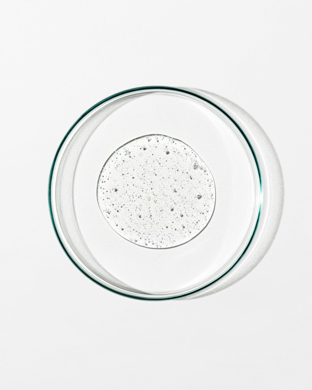 Clear glass bowl with a textured white liquid on a white background