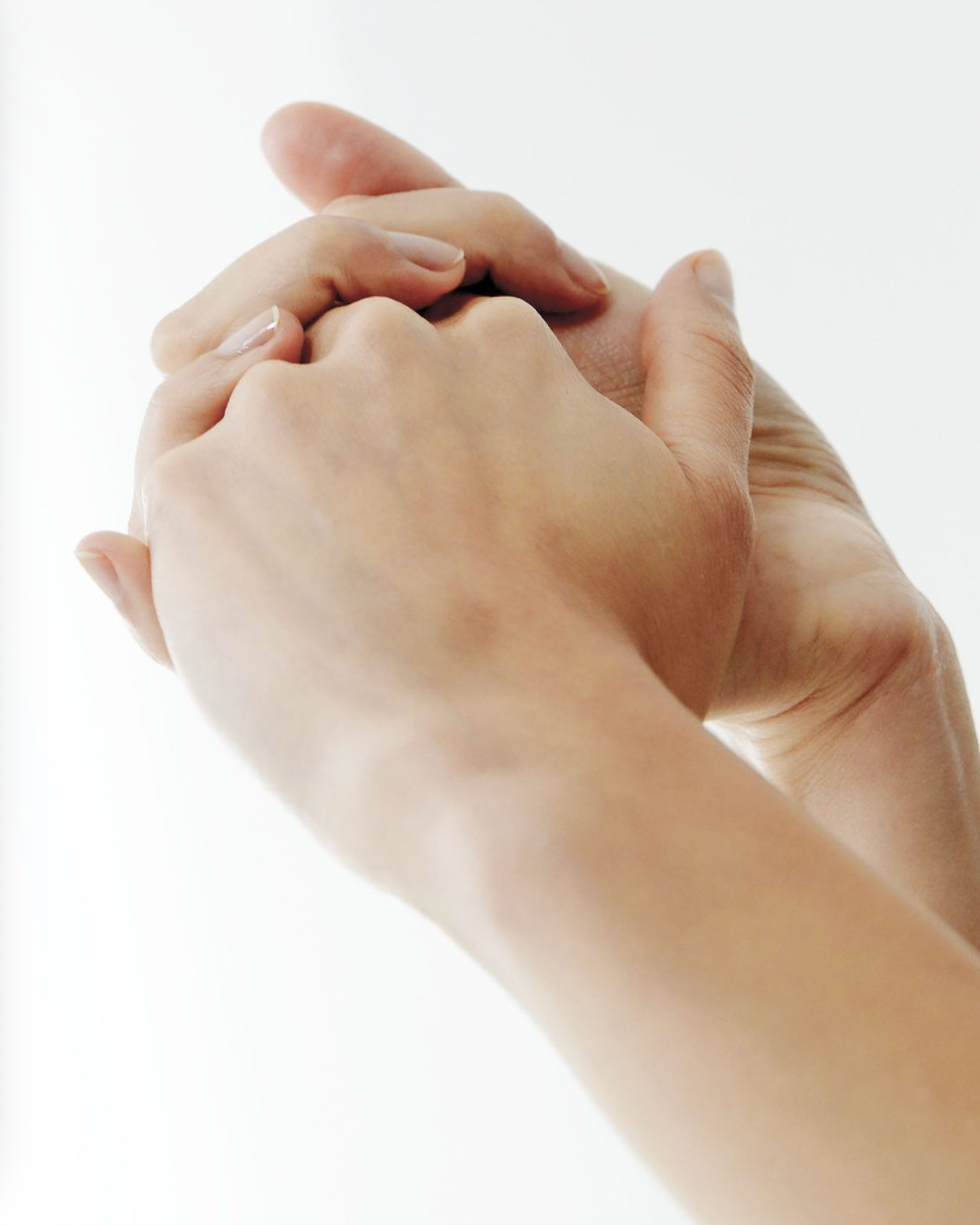Close-up of two hands applying cream on a white background