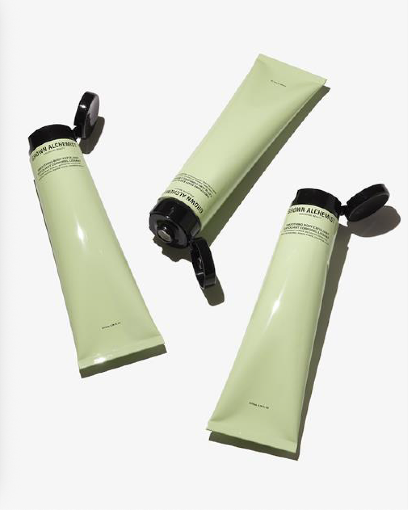 Three green Grown Alchemist tubes with black caps on a white background