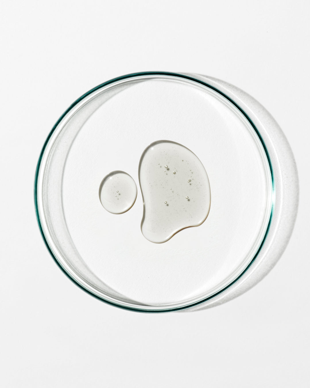 Clear glass lid with a small amount of white substance on a white background