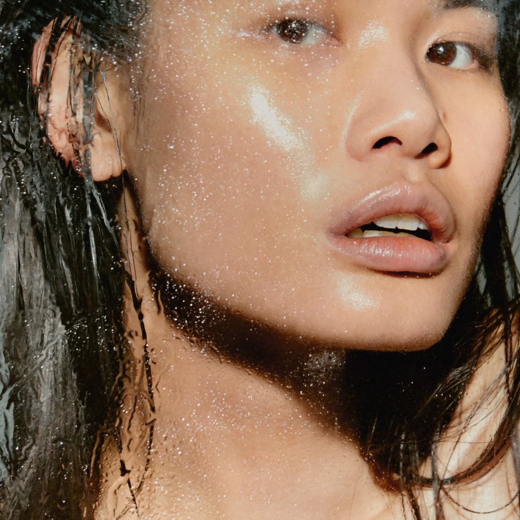 Close-up of a person with water droplets on their face and hair