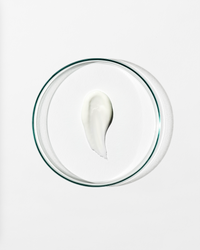 Clear dish with a dollop of white cream against a white background