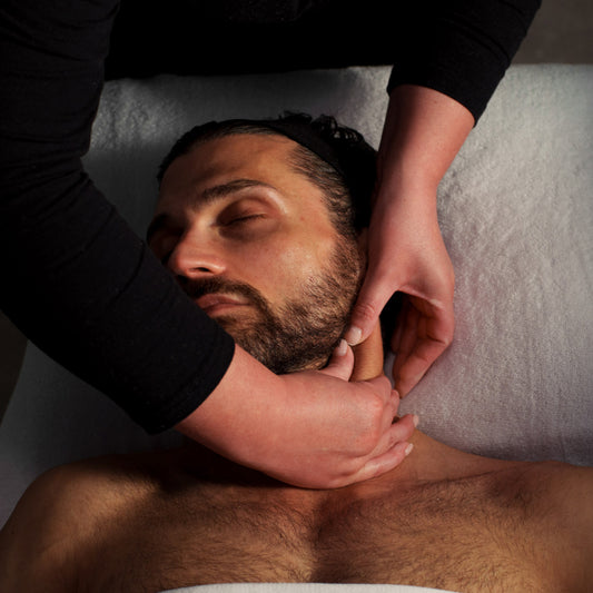 Man receiving a massage with a focus on the hands and face.