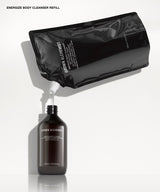 A black refill pouch labeled 'GROWN ALCHEMIST' pouring a liquid into a dark amber bottle also labeled 'GROWN ALCHEMIST' on a clean white background.