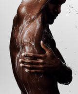 Shot of man in shower rinsing his body with cleanser.