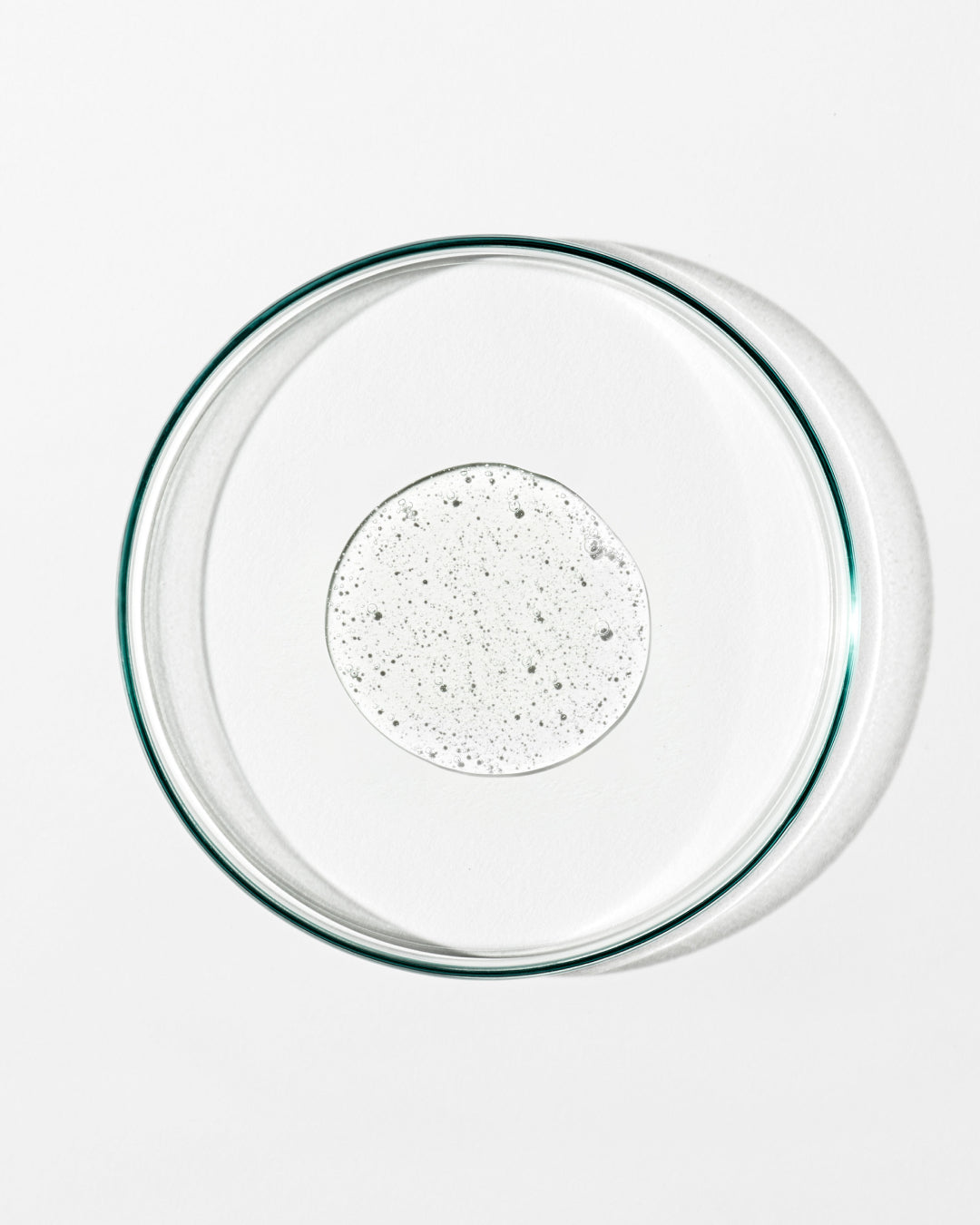 Clear glass pie dish with clear liquid on a white background