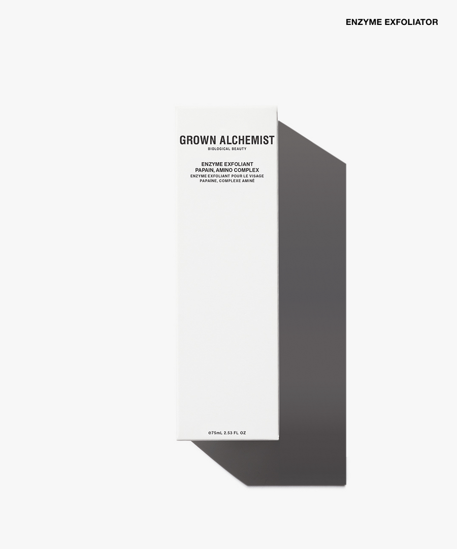 A tall, narrow white product box for Grown Alchemist Enzyme Exfoliator, shown on a clean white background with a soft gray shadow. The box features black text detailing the exfoliating facial peel.