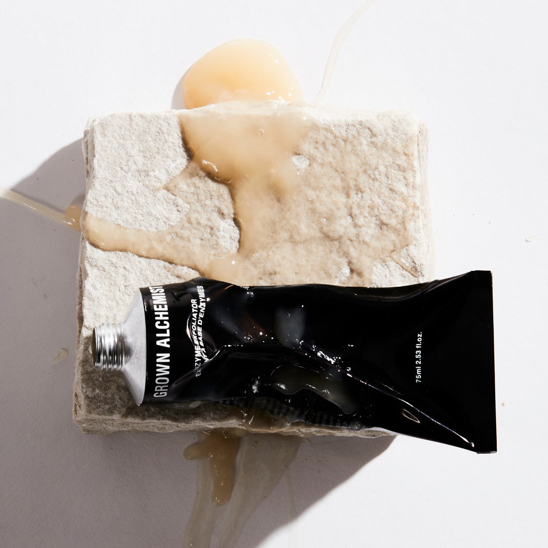 Grown Alchemist Enzyme Exfoliator tube with cream on a textured surface