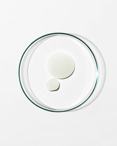 Clear glass lid with two white circular dollops of cream on a white background