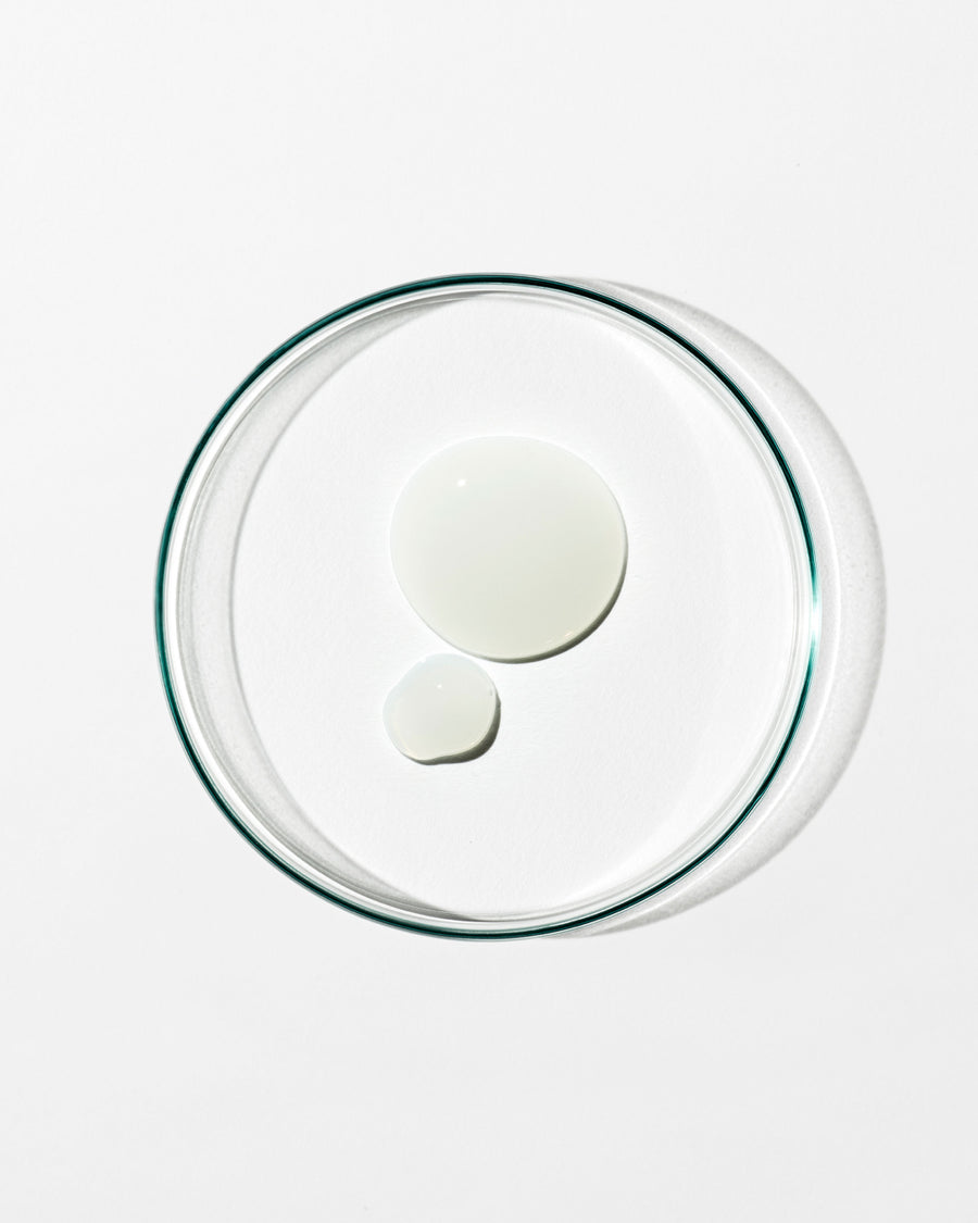 Clear glass lid with two white circular dollops of cream on a white background