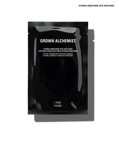 A single black Grown Alchemist Hydra-Restore Eye Patch sachet on a white background with a soft shadow.
