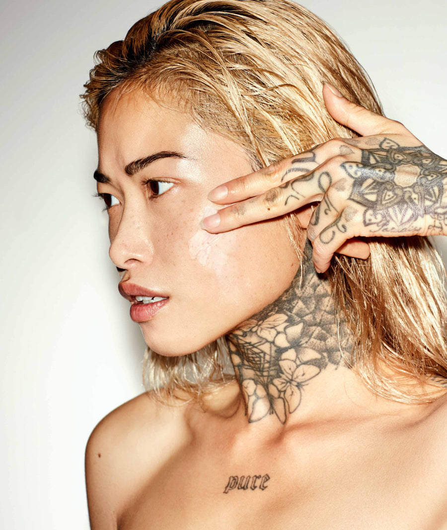 Photo of women applying cream to her face.
