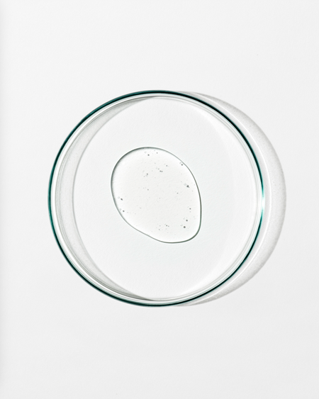 Clear dish whit clear liquid against a white background