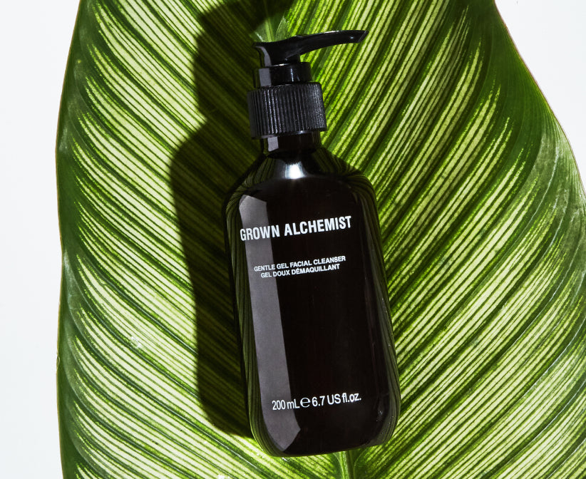 Pump bottle of Grown Alchemist product on a large green leaf