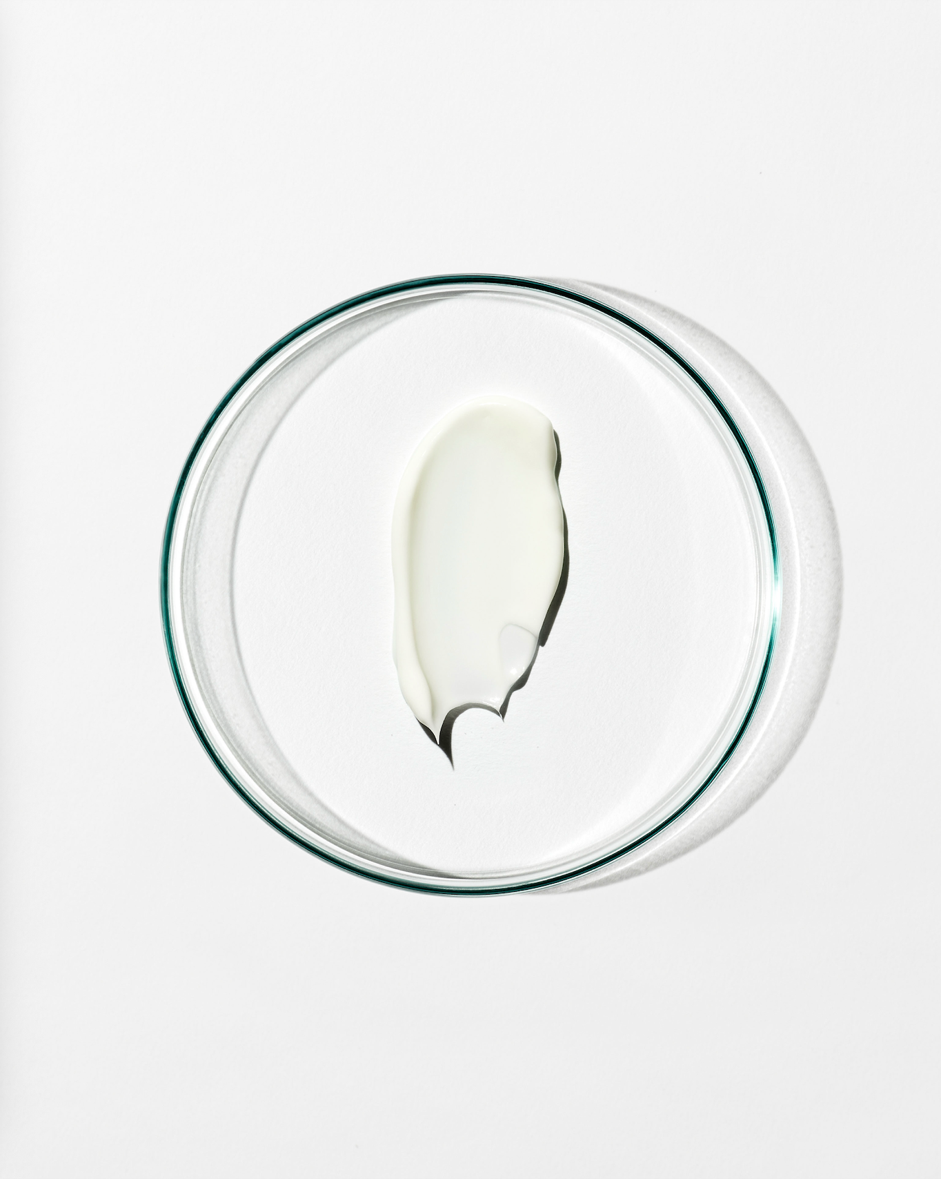 White dollop of cream on a clear glass bowl on a white background