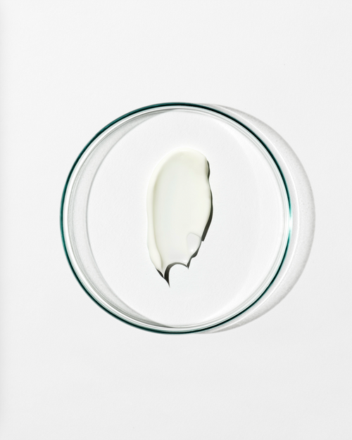 White dollop of cream on a clear glass bowl on a white background