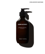 A dark amber pump bottle of Grown Alchemist Hydra-Restore Conditioner on a white background with a strong cast shadow.