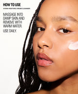 Close-up beauty ad showing part of a woman's face with text reading 'HOW TO USE HYDRA-RESTORE CREAM CLEANSER' and instructions on how to apply the cleanser. A white cream swatch is visible on her cheek against a clean white background.