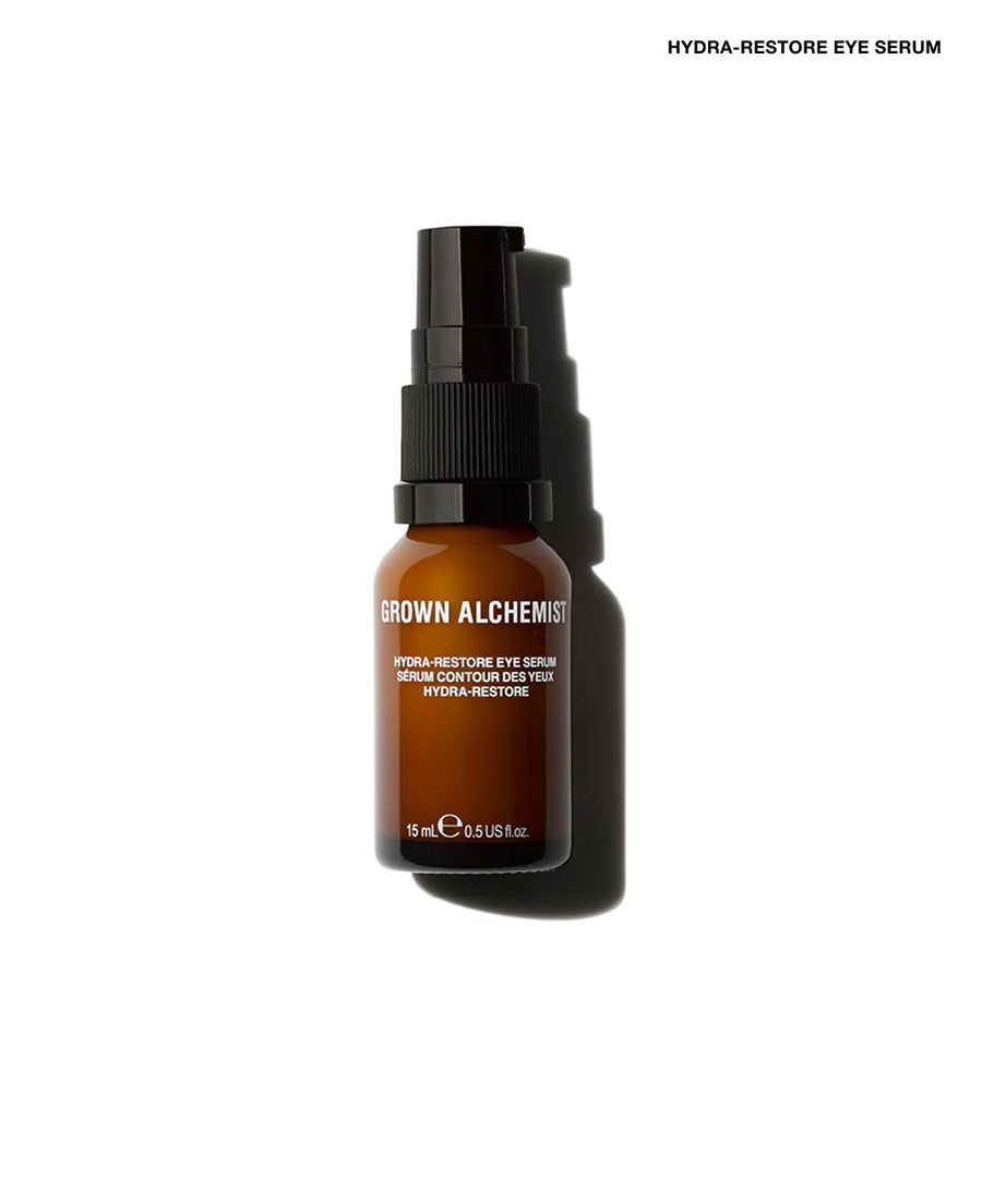 A 15ml amber glass bottle of GROWN ALCHEMIST Hydra-Restore Eye Serum with a black spray pump, shown on a clean white background with a soft shadow.