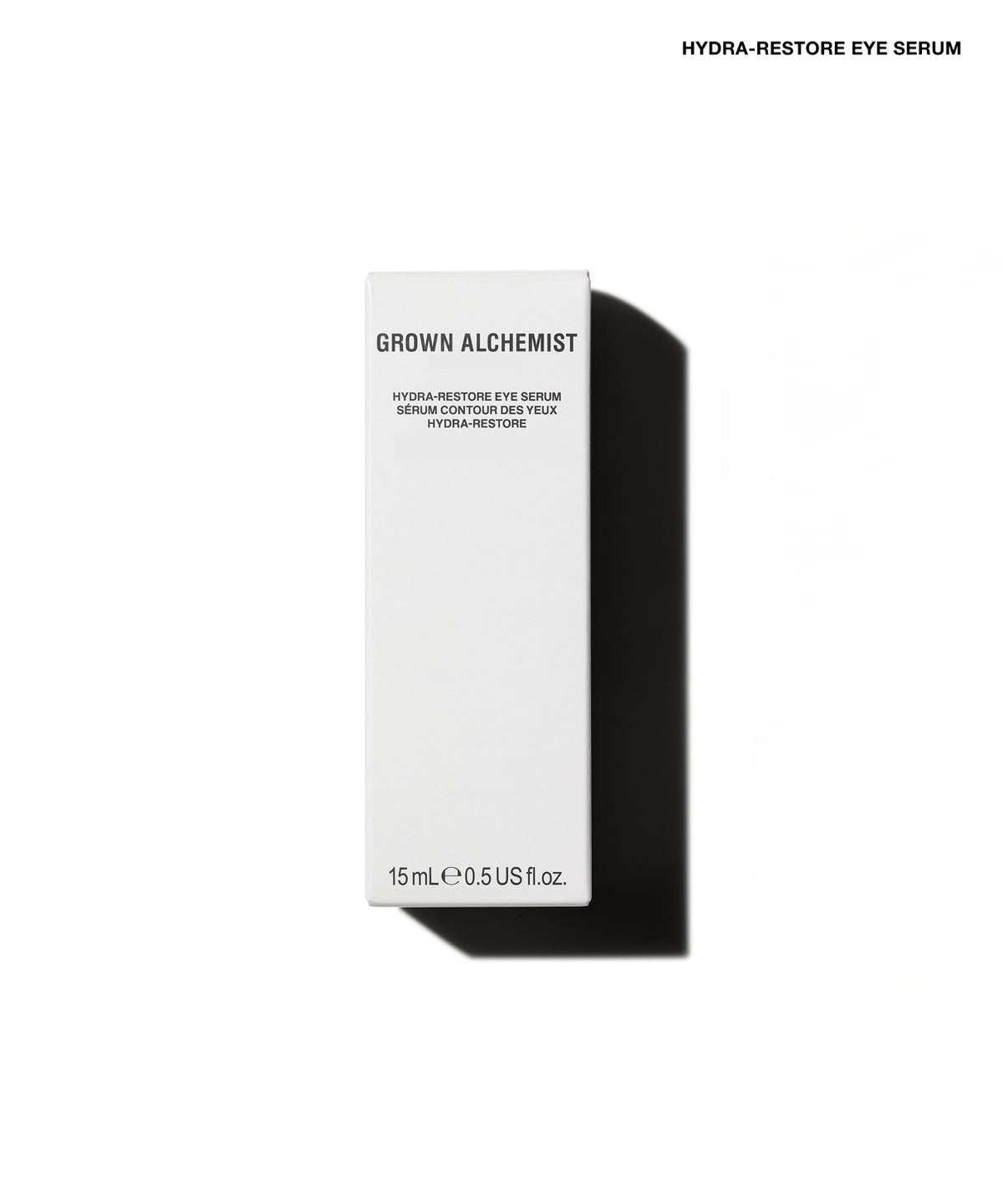 A tall, slim white rectangular box for Grown Alchemist Hydra-Restore Eye Serum, shown on a clean white background with a strong black shadow to the right. Small black text at the top right reads 'HYDRA-RESTORE EYE SERUM'.
