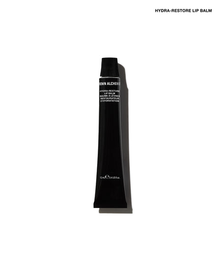 A single black cosmetic tube of Hydra-Restore Lip Balm, shown vertically against a plain white background with a soft shadow.