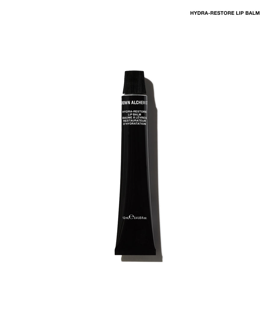 A single black cosmetic tube of Hydra-Restore Lip Balm, shown vertically against a plain white background with a soft shadow.