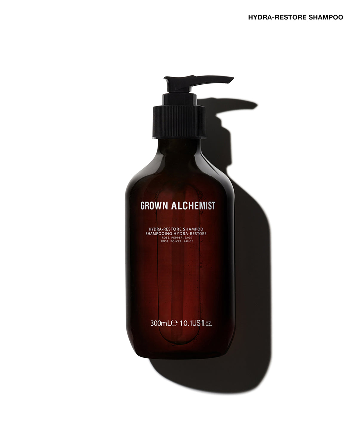 A 300mL dark amber glass pump bottle of Grown Alchemist Hydra-Restore Shampoo, shown on a white background with a dramatic shadow.