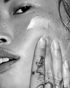 Close-up of a person putting cleanser on their face.