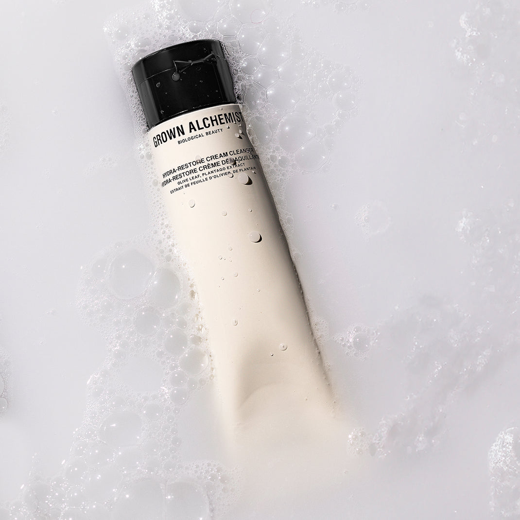 Bottle of Grown Alchemist cream cleanser on a textured white background
