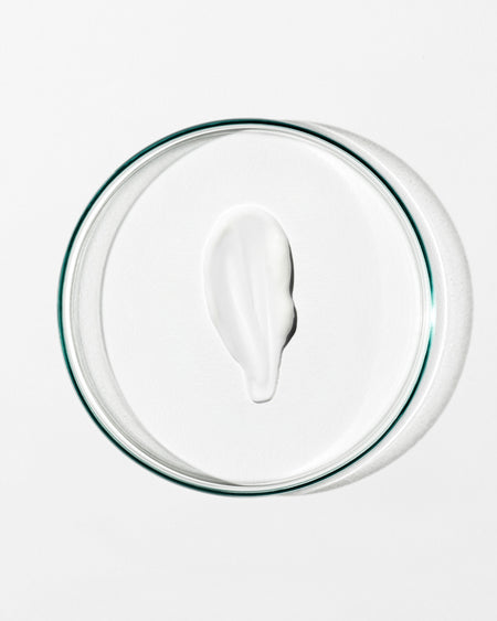 White cream in a clear glass bowl on a white background