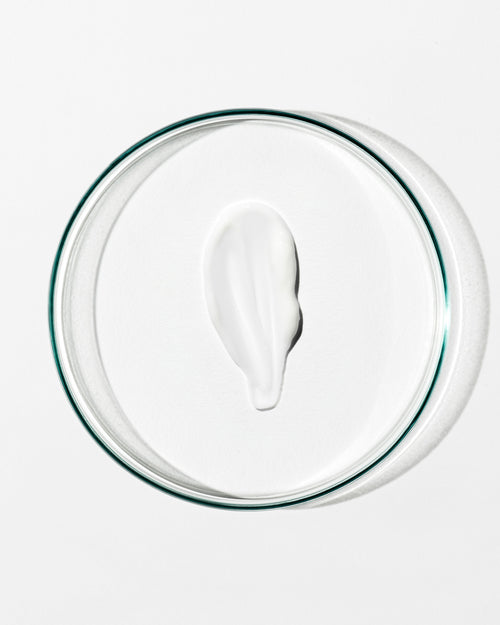 White cream on a clear glass plate with a white background