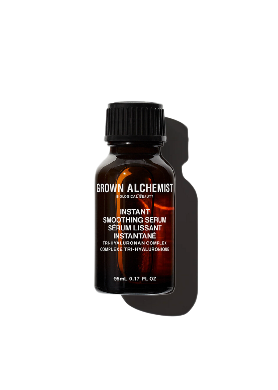 A bottle of Grown Alchemist Instant Smoothing Serum with a dark label and a clear, amber liquid visible inside.