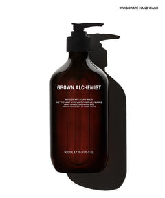 A 500 mL pump bottle of Grown Alchemist Invigorate Hand Wash in a dark amber-brown translucent bottle with a black pump, shown against a white background with a prominent black shadow.
