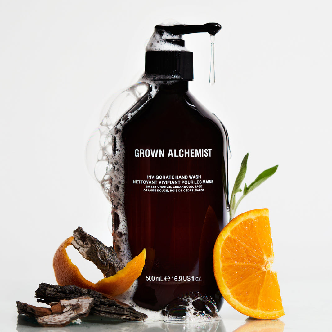 Grown Alchemist hand wash bottle with orange slices and peels on a white background
