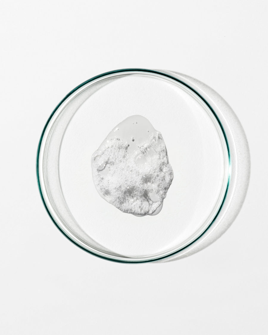 Clear glass bowl with a white foamy substance on a white background