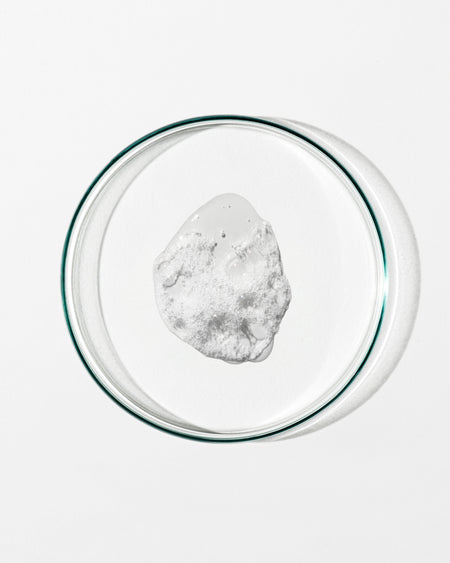 Clear glass bowl with a white liquid on a white background