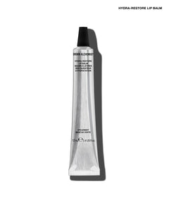 A single tube of GROW ALCHEMY Hydra-Restore Lip Balm on a clean white background with a soft shadow. The tube is metallic silver with a black cap, and the text 'HYDRA-RESTORE LIP BALM' is printed at the top right.