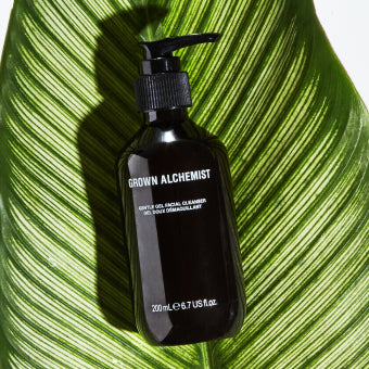Pump bottle of Grown Alchemist product on a large green leaf