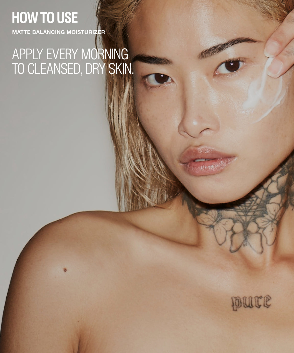 Close-up beauty editorial photo of a woman with blonde hair and visible neck/chest tattoos, applying a white cream to her face. Large text on the left reads 'HOW TO USE MATTE BALANCING MOISTURIZER' and 'APPLY EVERY MORNING TO CLEANSED, DRY SKIN.