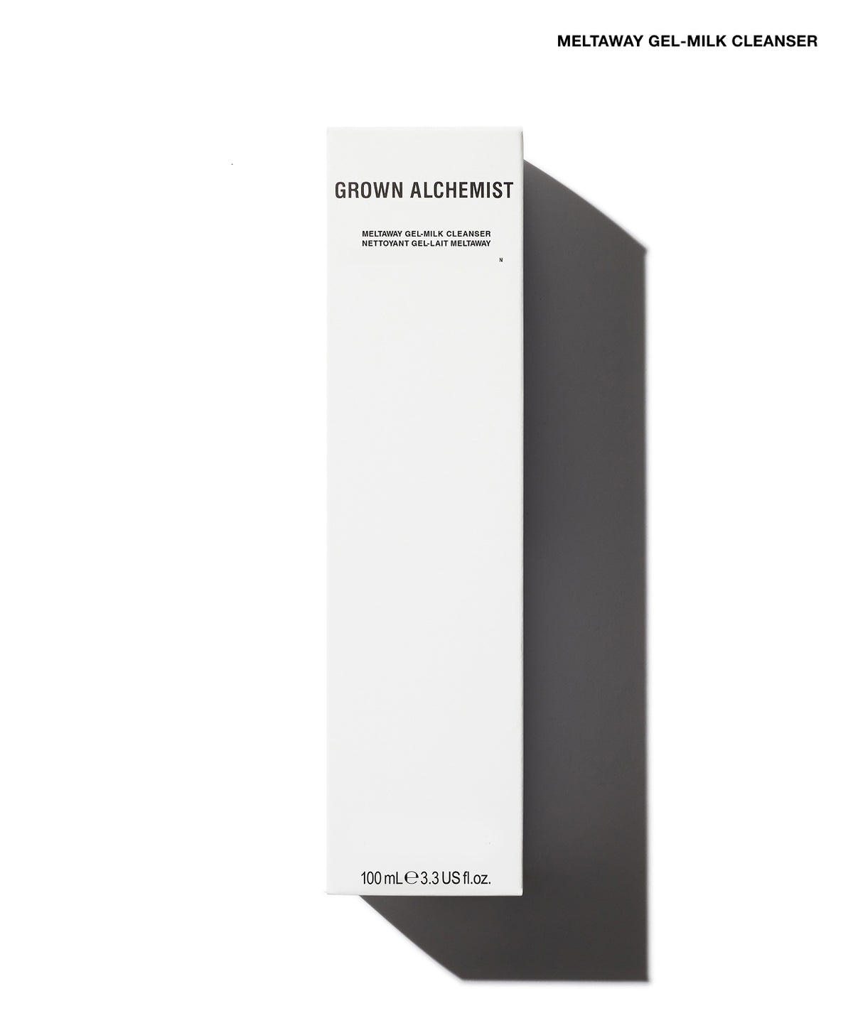 A tall, narrow white box for Grown Alchemist Meltaway Gel-Milk Cleanser, shown on a white background with a strong dark shadow to the right. The box has black text and is photographed from a top-down angle.
