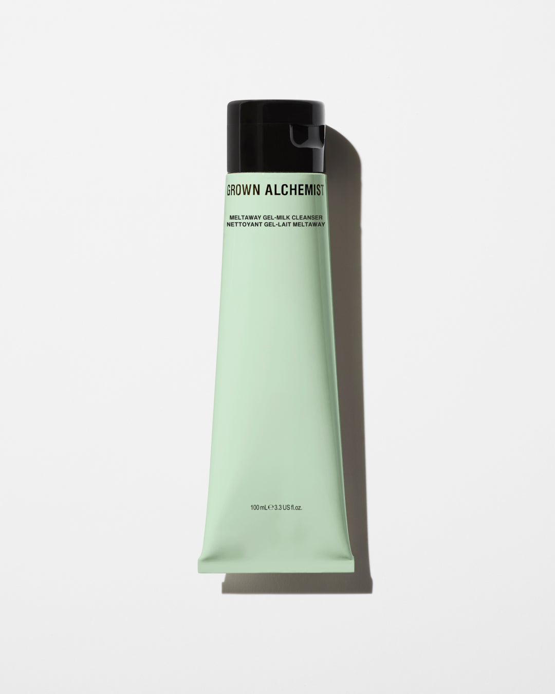 Green tube of Grown Alchemist product on a white background