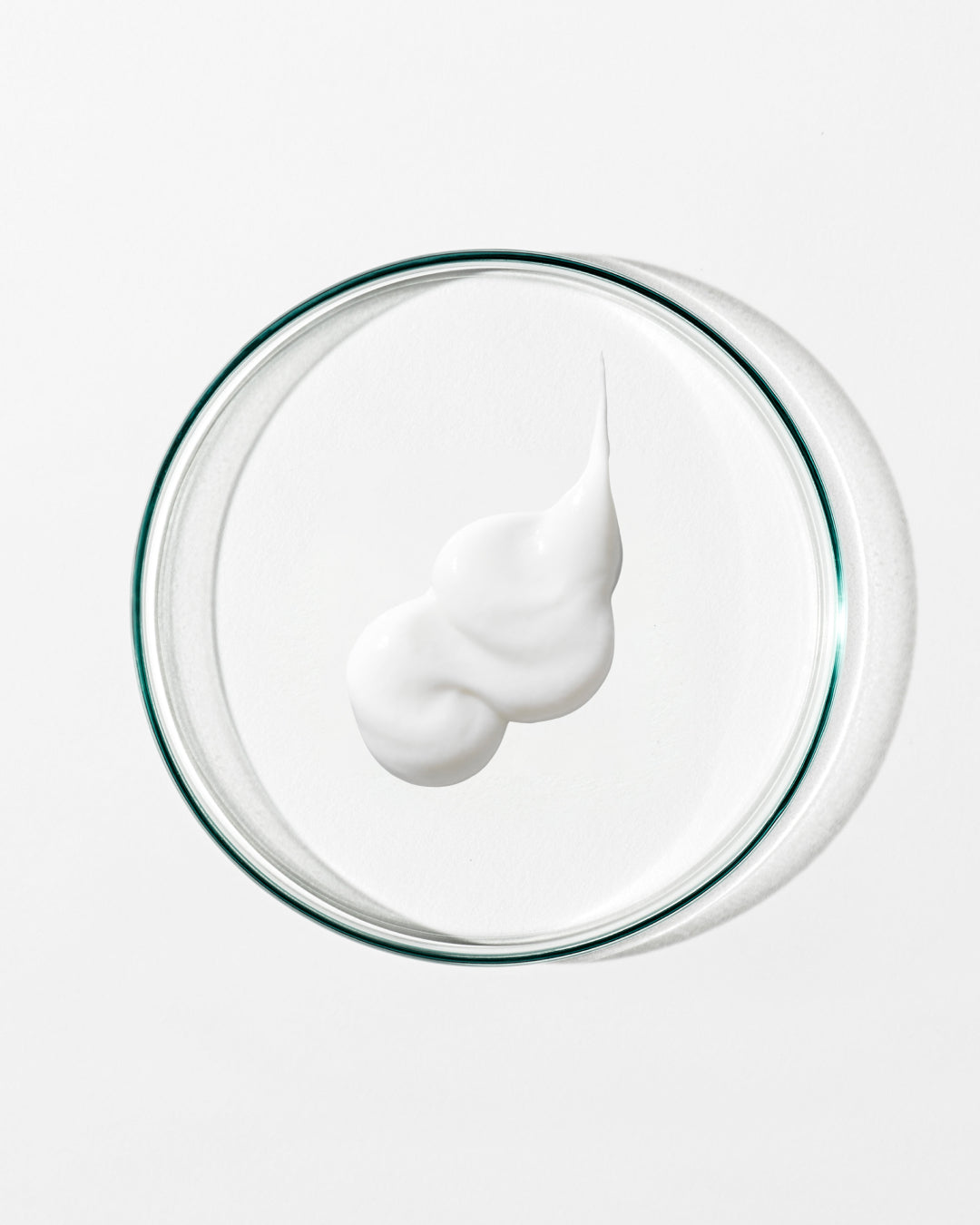 White cream on a clear glass plate with a white background