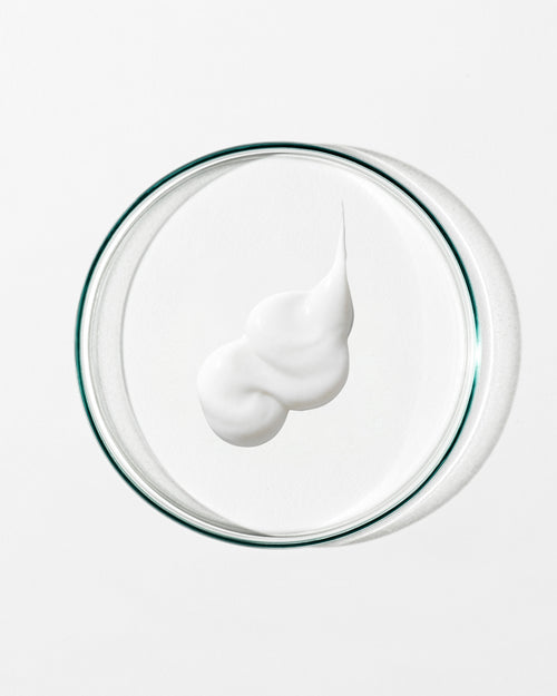 White cream on a clear glass plate with a white background