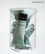 A clear glass jar filled with multiple tubes of GROWN ALCHEMIST regenerating gel mask in a pale sage green color, set against a clean white background.